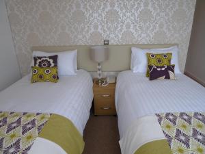 two beds sitting next to each other in a bedroom at Ashburnham Hotel in Pembrey