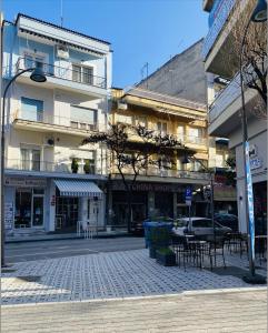 una via cittadina con tavoli e sedie di fronte agli edifici di Toucan Suites a Édessa