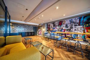 a room with couches and tables and a mural at Vienna House Easy by Wyndham Dortmund City in Dortmund
