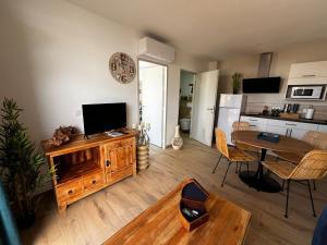 a living room with a television and a dining room table at Sun Oasis Les Tamaris in Bretignolles-sur-Mer