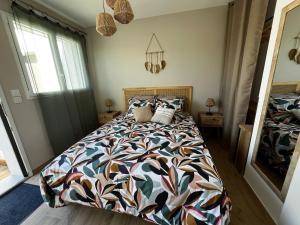 a bedroom with a bed with a colorful comforter at Sun Oasis Les Tamaris in Bretignolles-sur-Mer