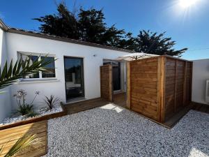 a backyard of a house with a wooden fence at Sun Oasis Les Tamaris in Bretignolles-sur-Mer +2 photos
