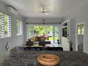a living room with a couch and a table at Drydens Creek Retreat in Ngatangiia