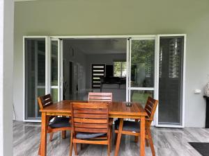 a wooden dining room table with four chairs at Drydens Creek Retreat in Ngatangiia