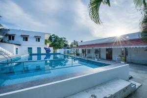 a swimming pool in front of a building at Le Epic Resort in Virāmpattinam
