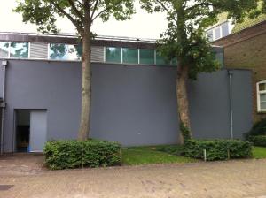 un bâtiment avec deux arbres devant lui dans l'établissement B&B De Kloostertuin, à Middelbourg