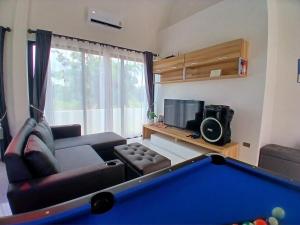 a living room with a couch and a pool table at Level UP pool villa Rayong in Rayong