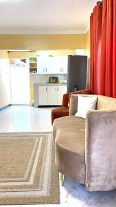 a living room with a couch and red curtains at Spacious City Home in Kampala