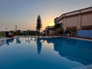 a large blue swimming pool in front of a building at Hotel Padmini Palace in Rāni Pokhri