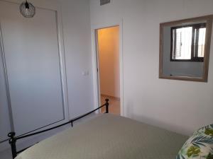 a bedroom with a bed and a window and a mirror at Brand new Apartment in Mar de Pulpi in Pulpí +36 photos