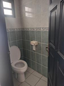 a bathroom with a toilet and a window and a door at KAZANNa in Sainte-Clotilde +7 photos