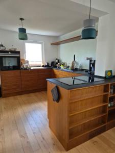 una cucina con armadi in legno e piano di lavoro nero di Charmantes Ferienhaus in Alsfeld-Eifa ad Alsfeld