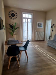 a living room with a table and chairs and a clock at Alemanni54 - Apartment in Bologna