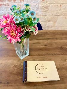 a card next to a vase of flowers on a table at Iaru-Bed Experience House in Alberobello