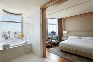 a bedroom with a bed and a bath tub and a sink at Bangkok Marriott Hotel Sukhumvit in Bangkok