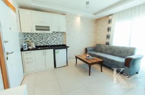 a living room with a couch and a table at Mersin Kent Suit Hotel in Mezitli