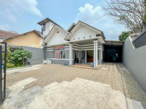 a house with a driveway in front of it at Wisma Air Mancur Malang Mitra RedDoorz in Malang