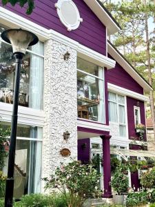 ein lila-weißes Haus mit Straßenbeleuchtung in der Unterkunft Violet Villa Đà Lạt in Xuan An
