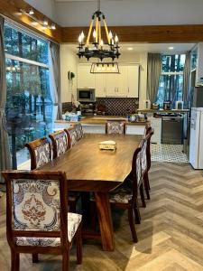 eine Küche und ein Esszimmer mit einem Holztisch und Stühlen in der Unterkunft Violet Villa Đà Lạt in Xuan An