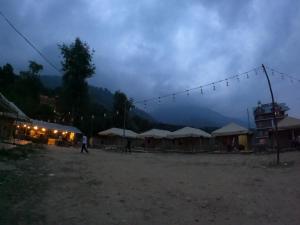 a group of umbrellas and tents in a field at Soma Caves Tents in Jagatsukh +19 photos