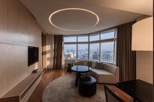 a living room with a couch and a table at Bangkok Marriott Hotel Sukhumvit in Bangkok