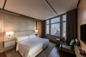 a hotel room with a bed and a large window at Bangkok Marriott Hotel Sukhumvit in Bangkok
