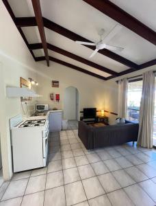 una cucina e un soggiorno con piano cottura e divano di Wildsights Villas a Denham