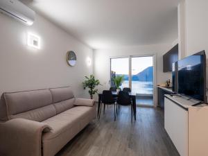 a living room with a couch and a table with chairs at Ciclamino House in Bellano