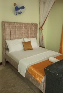 a large bed in a room with a window at Mtwapa june apartment 2 in Mombasa