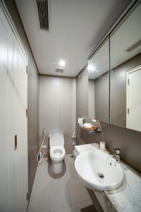 a bathroom with a white toilet and a sink at Rue De Coton in Hanoi