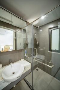 a bathroom with a sink and a glass shower at Rue De Coton in Hanoi