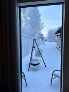 a swing in the snow outside a window at Guest house - Northern tealight in Rovaniemi +21 photos