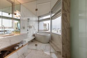 a bathroom with a tub and a sink at Bangkok Marriott Hotel Sukhumvit in Bangkok