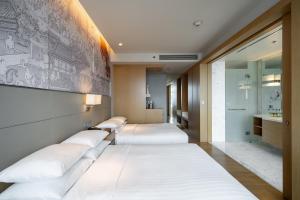 a row of beds in a hotel room at Bangkok Marriott Hotel Sukhumvit in Bangkok