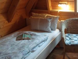 a room with a bed with a book and a chair at Weitblick in Dorum-Neufeld +32 photos