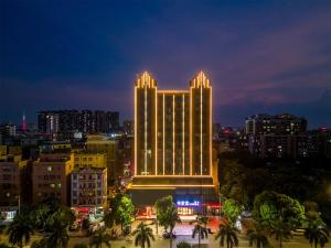 duży budynek z oświetleniem w nocy w obiekcie Calvin International Hotel Guangzhou Baiyun International Airport Huadu Plaza Branch - Free Deliver Service to Guangzhou Baiyun International Airport & Free Deliver Service to Canton Fair Complex During Canton Fair Period w mieście Huadu