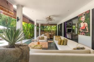 a living room with a white couch and a table at Villa Mahkai in Ambengan
