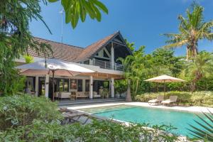 an exterior view of a house with a swimming pool at Villa Mahkai in Ambengan