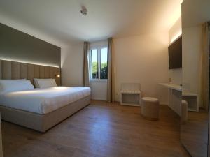 a bedroom with a large bed and a window at Castiglioncello Suite in Castiglioncello