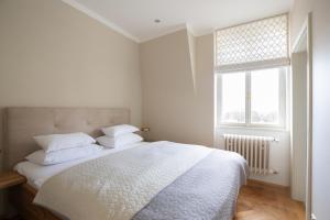 a bedroom with a bed with white sheets and a window at Husova 87 Rosewood Suite in Liberec