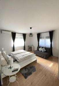 a bedroom with a bed and a table and a couch at 4 STARS APARTMENTS Near Airport in Velika Gorica