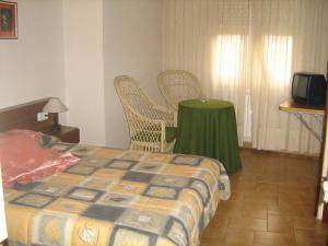 a bedroom with a bed and a table and chairs at Fonda Rita in Sant Hilari Sacalm