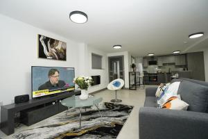 a living room with a couch and a tv at Leicestershire Aparthotels - Field Street Court in Shepshed