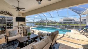 een woonkamer met een bank en een zwembad bij Charming County Villa 5874 in Punta Gorda Isles in Punta Gorda