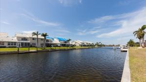 een kanaal met huizen en een boot in het water bij Charming County Villa 5874 in Punta Gorda Isles in Punta Gorda