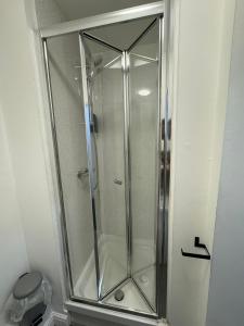 a shower with a glass door in a bathroom at St James's Terrace Studio Rooms in Nottingham