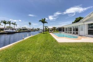 a house with a swimming pool next to a body of water at Relaxing Charlotte County Villa 5881 with Private Pool Access in Punta Gorda