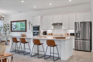 eine Küche mit weißen Schränken und eine große Insel mit Barhockern in der Unterkunft Charlotte County 5886: Perfect Gulf Coast Retreat in Port Charlotte