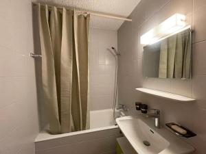 a bathroom with a shower curtain and a sink at Appart La Fouly in La Fouly