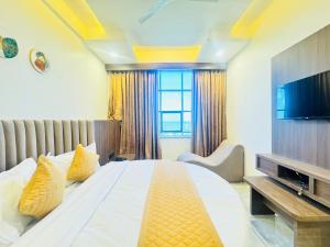 a bedroom with a large bed and a television at Hotel Lee Paramount in Gandhinagar